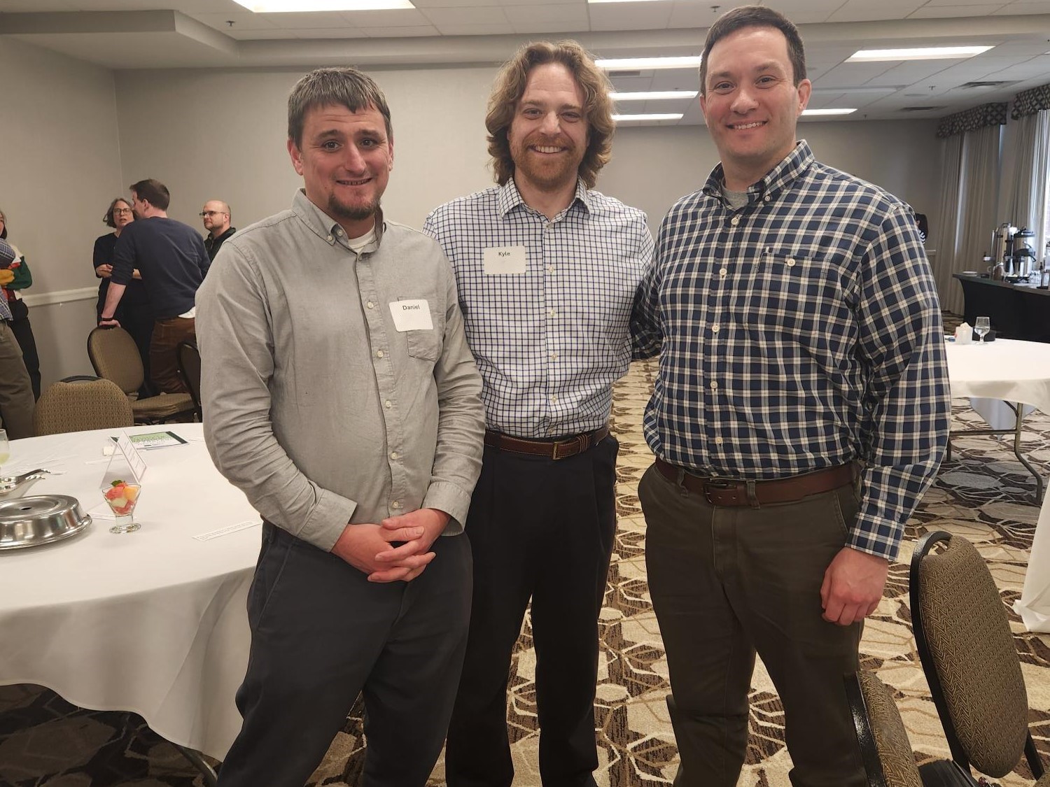 Three lawyers at a housing conference smile for the camera