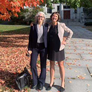 Two female VLA lawyers stand in front of a courthouse